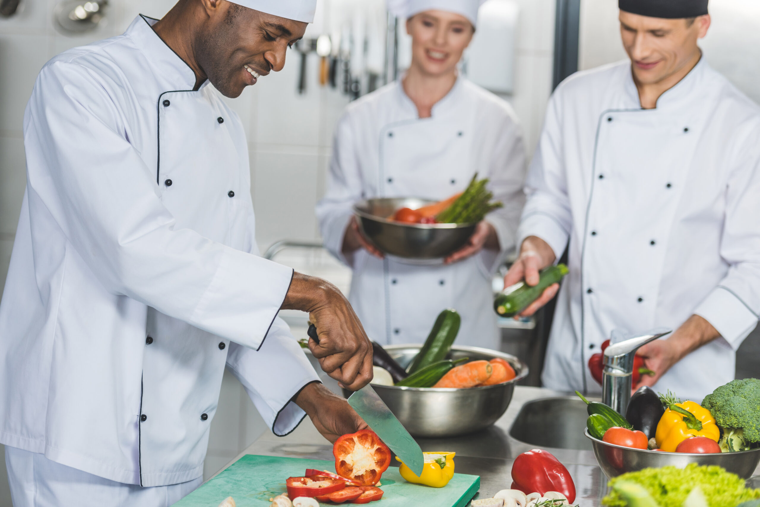 multicultural chefs cooking salad at restaurant kitchen